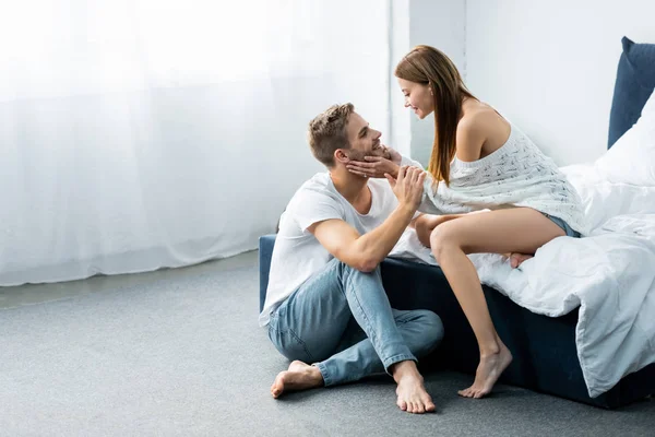 Vue latérale de attrayant et souriant femme étreignant bel homme — Photo de stock