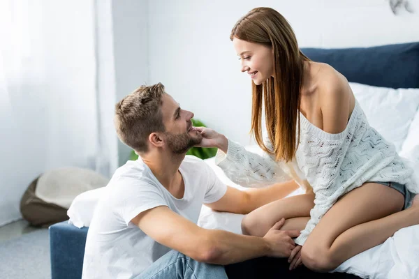 Vue latérale de attrayant et souriant femme étreignant bel homme — Photo de stock