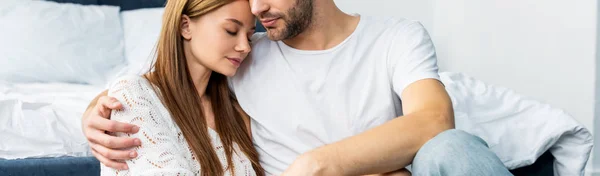 Panoramic shot of man hugging attractive woman with closed eyes — Stock Photo