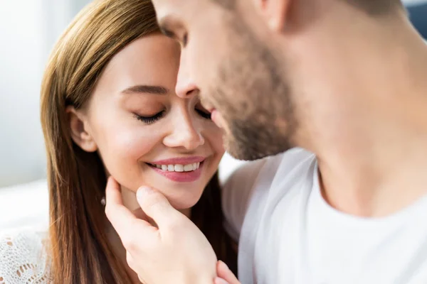 Selective focus of man hugging attractive and smiling woman — Stock Photo