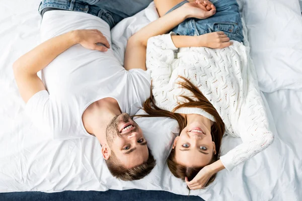 Vista dall'alto di bell'uomo e donna sorridente che guarda la fotocamera in appartamento — Foto stock