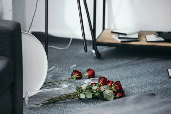 Flores e vaso quebrado no chão em apartamento roubado — Fotografia de Stock