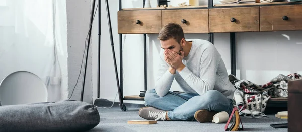 Colpo panoramico di uomo bello e scioccato oscurando il viso in appartamento derubato — Foto stock