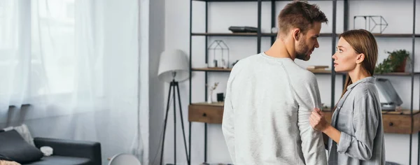 Tiro panorâmico de mulher atraente conversando com homem bonito em apartamento roubado — Fotografia de Stock