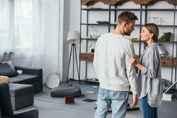 Приваблива жінка розмовляє з красивим чоловіком в пограбованій квартирі — стокове фото