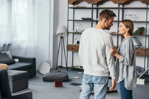 Atractiva mujer hablando con un hombre guapo en apartamento robado - foto de stock