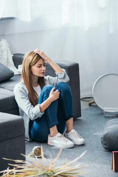 Attraente e triste donna seduta sul pavimento in appartamento derubato — Foto stock