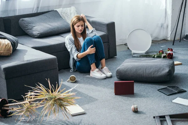 Mulher atraente e triste sentado no chão em apartamento roubado — Fotografia de Stock