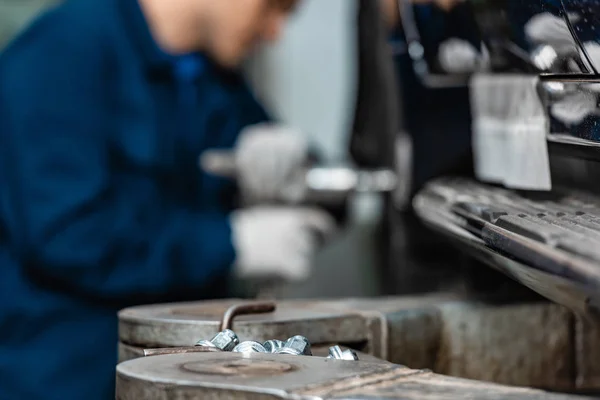 Selective focus of mechanic adjusting brakes with pneumatic wrench — Stock Photo