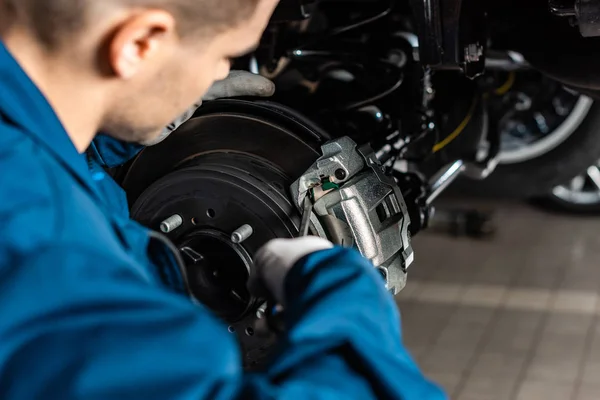 Selective focus of mechanic adjusting brake caliper with screw driver — Stock Photo