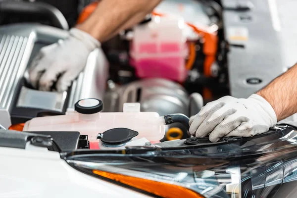 Vista recortada del mecánico que inspecciona el compartimiento del motor del coche - foto de stock