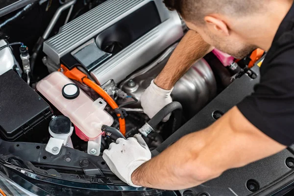 Visão aérea do jovem mecânico que inspeciona o compartimento do motor do carro — Fotografia de Stock