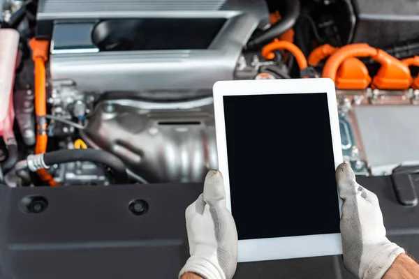 Ausgeschnittene Ansicht des Mechanikers, der ein digitales Tablet mit leerem Bildschirm in der Nähe des Motorraums hält — Stockfoto