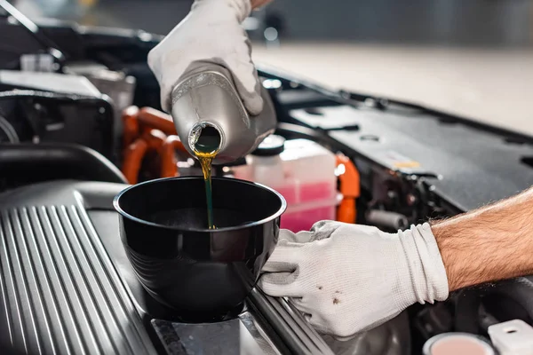 Ausgeschnittene Ansicht eines Mechanikers, der Öl in den Automotor gießt — Stockfoto
