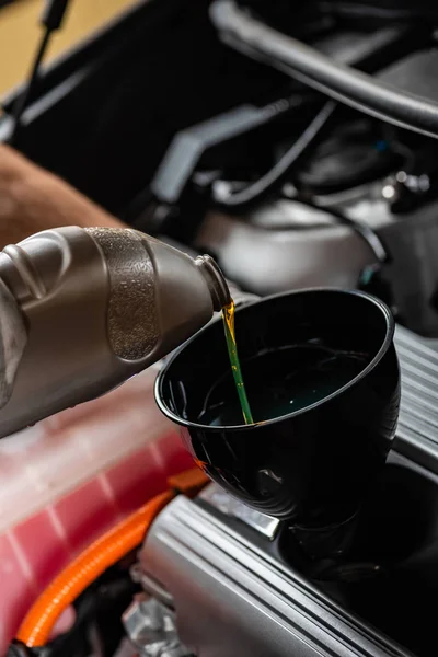 Partial view of mechanic pouring motor oil at car engine — Stock Photo