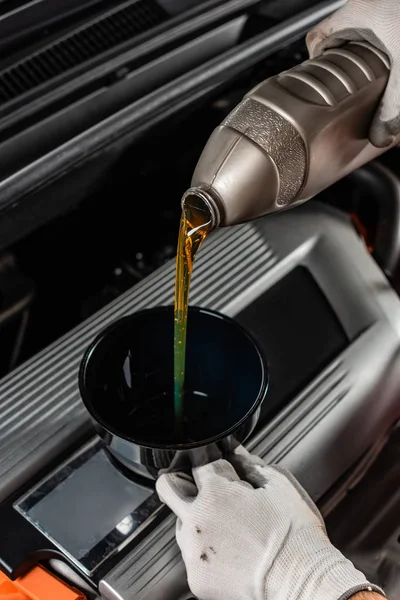 Partial view of mechanic pouring machine oil at car engine — Stock Photo