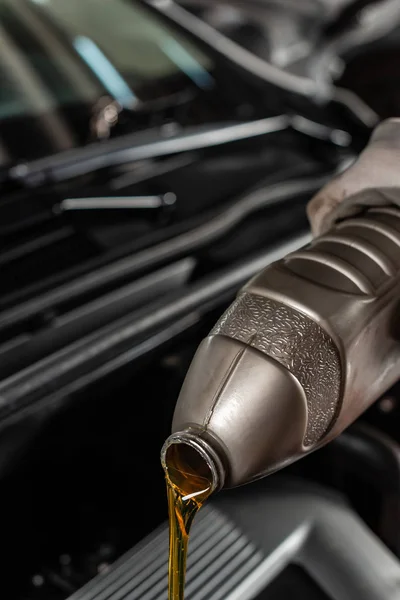 Ausgeschnittene Ansicht eines Mechanikers, der Schmieröl aus der Flasche gießt — Stockfoto