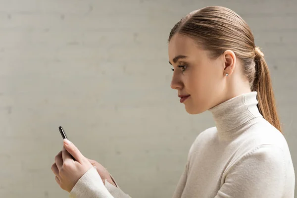 Side view of attractive woman using smartphone — Stock Photo