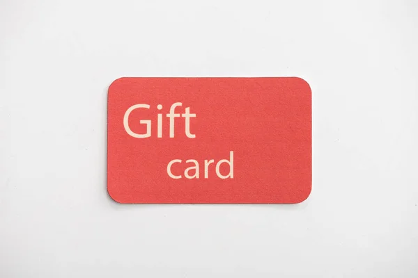 Top view of red gift card on white surface — Stock Photo