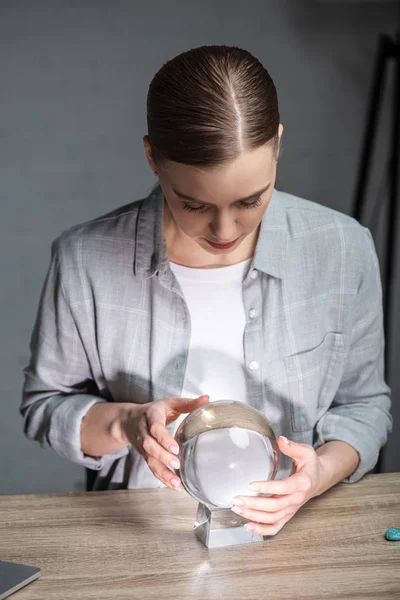 Belo astrólogo usando bola de cristal na mesa de madeira — Fotografia de Stock