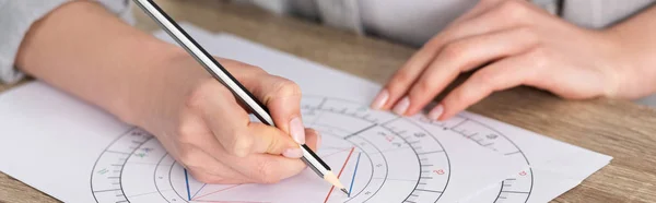 Cropped view of astrologer drawing natal chart on wooden table, panoramic shot — Stock Photo