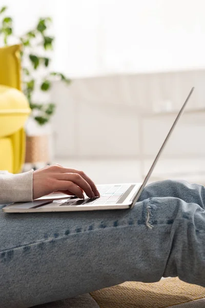 Vista cortada do freelancer usando laptop no chão na sala de estar — Fotografia de Stock