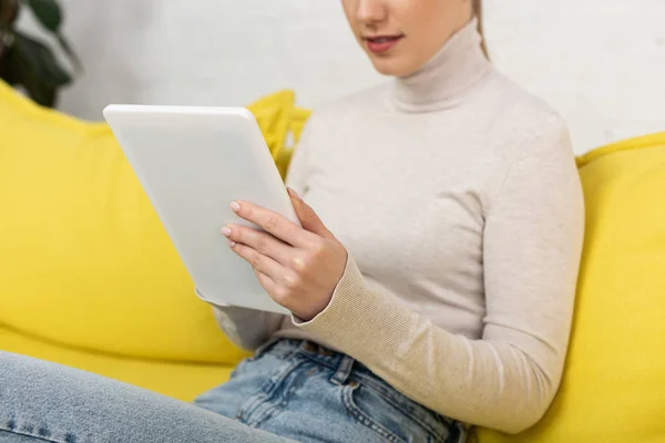 Vista ritagliata di giovane donna che utilizza tablet digitale sul divano — Stock Photo
