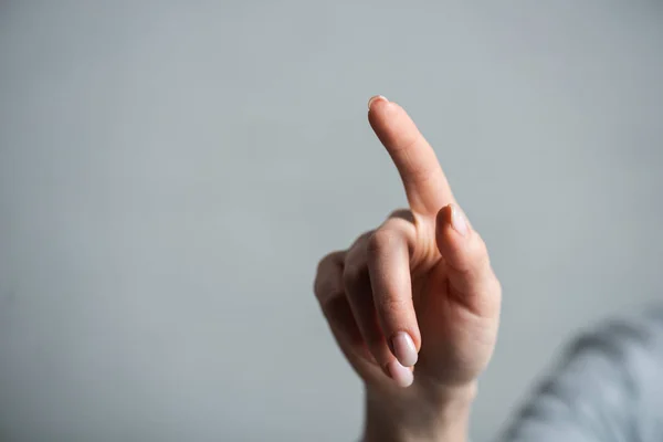 Vista ritagliata della donna che punta con il dito isolato sul grigio — Foto stock