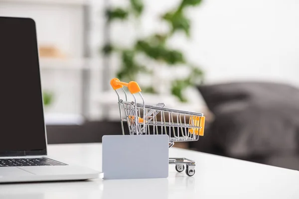 Spielzeugwagen mit Kreditkarte und Laptop auf dem Tisch — Stockfoto