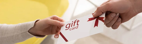 Cropped view of man giving gift card to woman, panoramic shot — Stock Photo