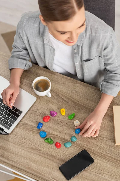 Astrologe mit Laptop, Steinen mit Tierkreiszeichen und Kaffee auf dem Tisch — Stockfoto