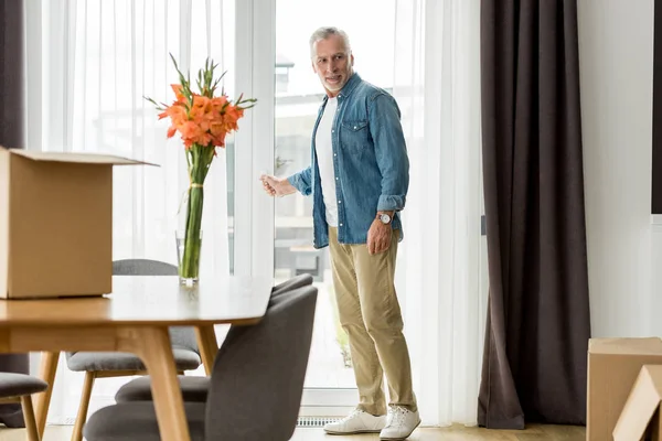 Handsome mature man in shirt standing in new house — Stock Photo