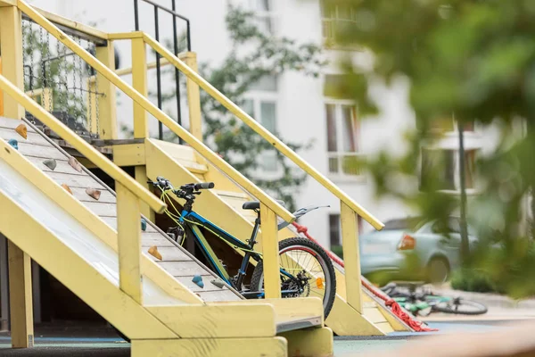 Selective focus of playground, bike and building on background — Stock Photo