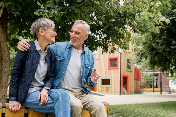 Mature man hugging smiling woman and looking at her — Stock Photo