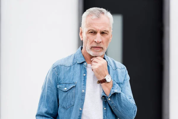 Nachdenklicher älterer Mann im Hemd schaut in der Nähe des neuen Hauses weg — Stockfoto