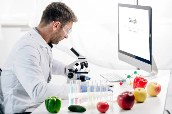 KYIV, UKRAINE - OUTUBRO 4, 2019: visão lateral do nutricionista molecular usando o computador com o site do Google — Fotografia de Stock