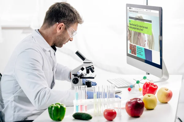 KYIV, UKRAINE - OCTOBER 4, 2019: side view of molecular nutritionist using computer with bbc website — Stock Photo
