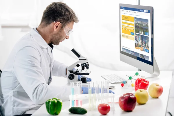 KYIV, UKRAINE - OCTOBER 4, 2019: side view of molecular nutritionist using computer with booking website — Stock Photo