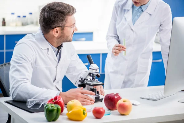 Visão cortada de nutricionista molecular conversando com colega em laboratório — Fotografia de Stock