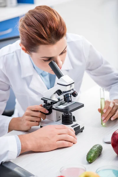 Nutritionniste moléculaire en pelage blanc au microscope en laboratoire — Photo de stock