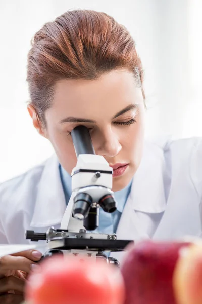 Selective focus of molecular nutritionist using microscope in lab — Stock Photo