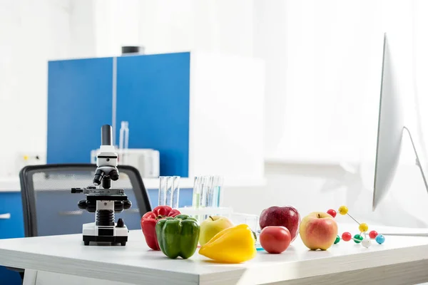 Microscope, fruit, vegetables, test tubes on table in lab — Stock Photo