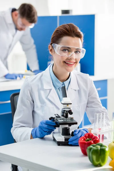 Selective focus of smiling molecular nutritionist looking at camera — Stock Photo