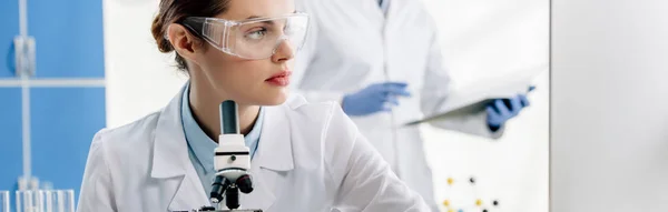 Tiro panorâmico de nutricionista molecular em óculos olhando para longe — Fotografia de Stock