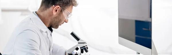 Prise de vue panoramique du nutritionniste moléculaire au microscope en laboratoire — Photo de stock