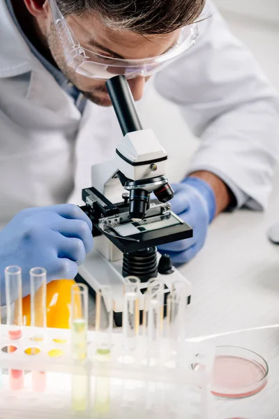 Vista recortada del nutricionista molecular usando microscopio en laboratorio - foto de stock