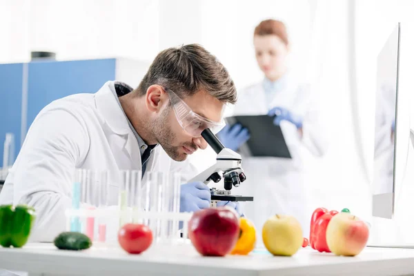 Selective focus of molecular nutritionist using microscope in lab — Stock Photo