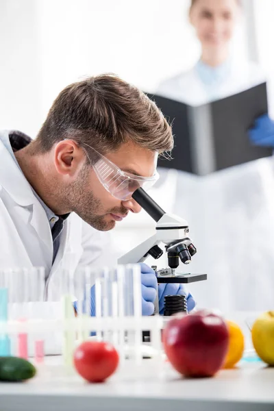 Foco seletivo do nutricionista molecular usando microscópio em laboratório — Fotografia de Stock