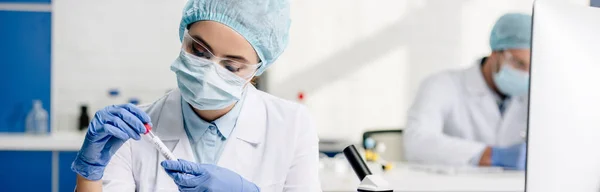 Tiro panorâmico do nutricionista molecular que prende o tubo de ensaio no laboratório — Fotografia de Stock