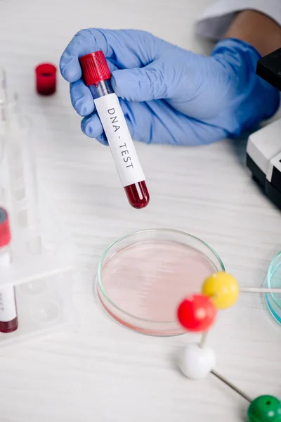 Cropped view of genetic consultant holding test tube with dna test lettering — Stock Photo